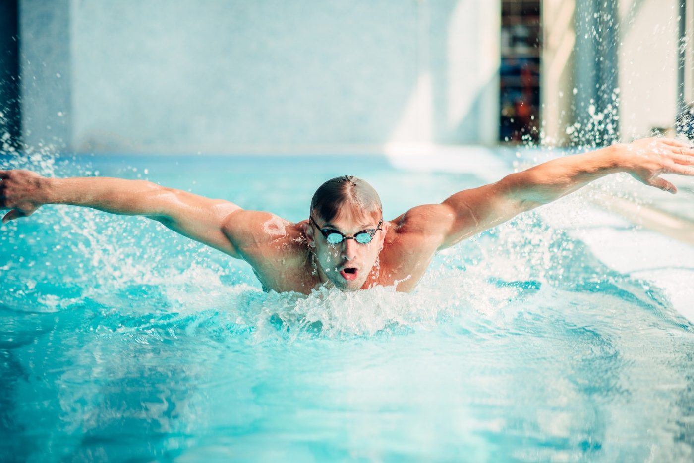 Athletic swimmer swims in butterfly style