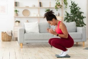 Black Lady Shouting Standing On Weight-Scales After Weight Gain Indoor
