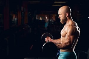 Muscled young man working out in the gym