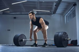 Man doing barbell exercise at gym during weight lifting workout