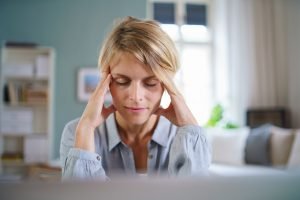Portrait of business woman meditating indoors in office at desk, mental health concept