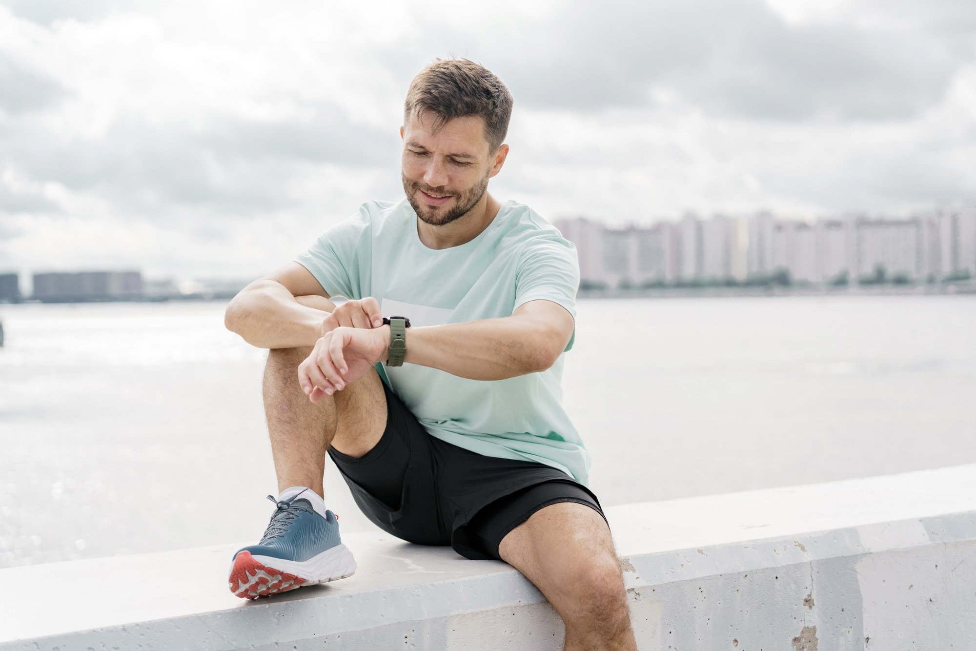 Looks at the screen Uses the app and a fitness watch on his hand. Trainer running man fitness trai