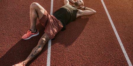 Runner lying on the track resting after workout