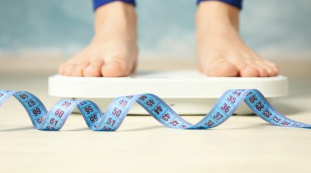 Woman stands on the scales. Measuring tape. Weight loss