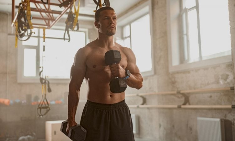 Young man going in for sport in gym