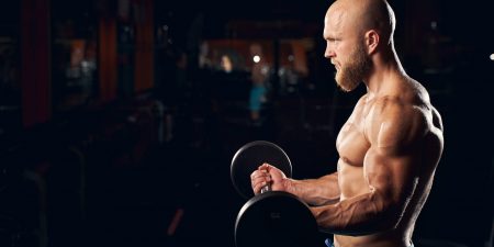 Muscled young man working out in the gym