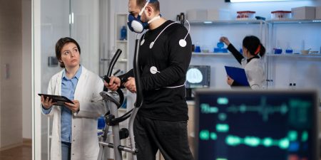 Sportman with medical electrodes on it running on fitness trainer working at body endurance