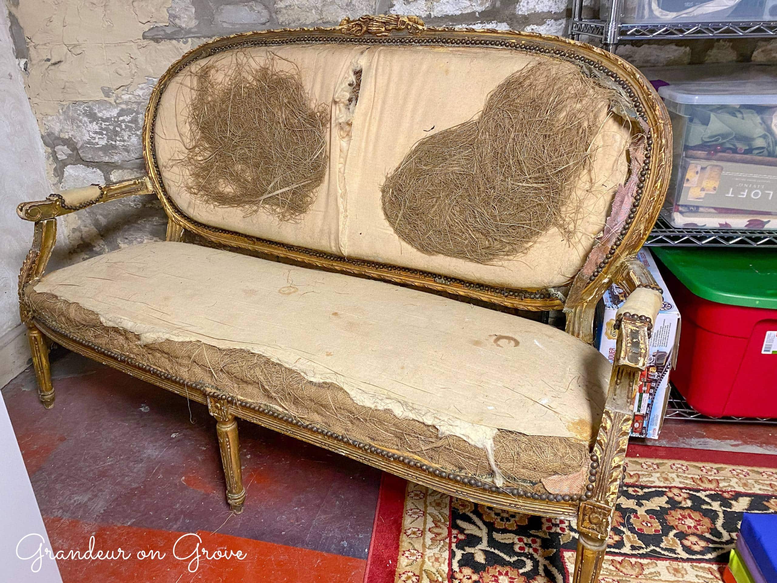 An antique french-style bench with upholstery fabric removed