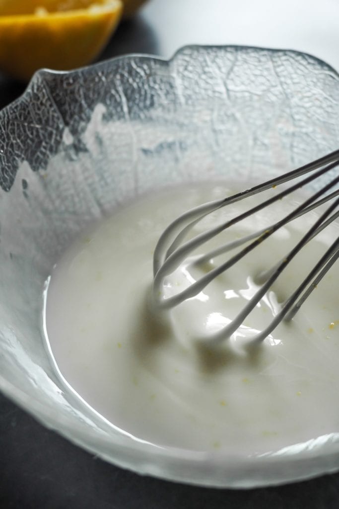 Recently made lemon glaze (lemon icing) in a bowl with a whisk | Paula's Apron Recipe