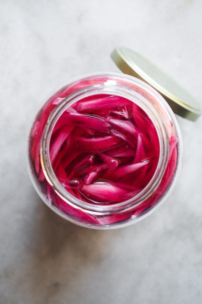 Making Homemade Pickled Onions couldn't be easier or quicker. And what do you get? A tangy, slightly sweet, and punchy onion made with just a handful of ingredients and a little bit of patience (some resting time is needed). It's a kitchen staple that you must include in your repertoire cause it's a super versatile flavour and colour booster. I'm sure that if you make this easy homemade pickled red onion once, you'll come back for more! | Paula's Apron Recipe