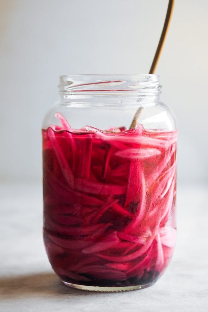 Making Homemade Pickled Onions couldn't be easier or quicker. And what do you get? A tangy, slightly sweet, and punchy onion made with just a handful of ingredients and a little bit of patience (some resting time is needed). It's a kitchen staple that you must include in your repertoire cause it's a super versatile flavour and colour booster. I'm sure that if you make this easy homemade pickled red onion once, you'll come back for more! | Paula's Apron Recipe