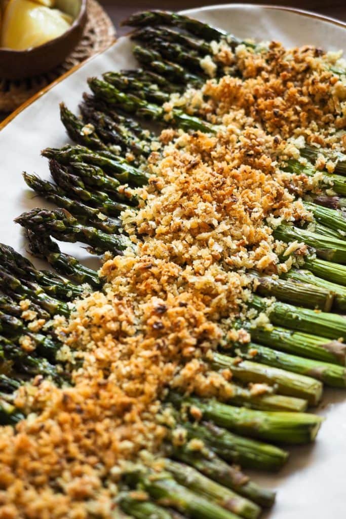 Estos Espárragos al Horno ​​con Crujiente de Ajo y Limón son un acompañamiento ideal para esta primavera. Imagínate espárragos a la brasa (porque el horno a alta temperatura los cuece de una forma parecida :P), pero con un extra crujiente con saborcito a limón y ajo, ¡brutal! Además, este crujiente añade textura y es perfecto para variar de los clásicos espárragos asados. | Receta de Paula's Apron