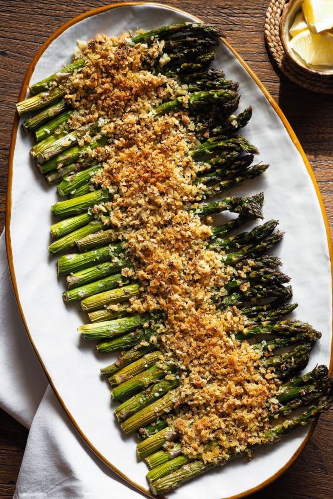 Estos Espárragos al Horno ​​con Crujiente de Ajo y Limón son un acompañamiento ideal para esta primavera. Imagínate espárragos a la brasa (porque el horno a alta temperatura los cuece de una forma parecida :P), pero con un extra crujiente con saborcito a limón y ajo, ¡brutal! Además, este crujiente añade textura y es perfecto para variar de los clásicos espárragos asados. | Receta de Paula's Apron