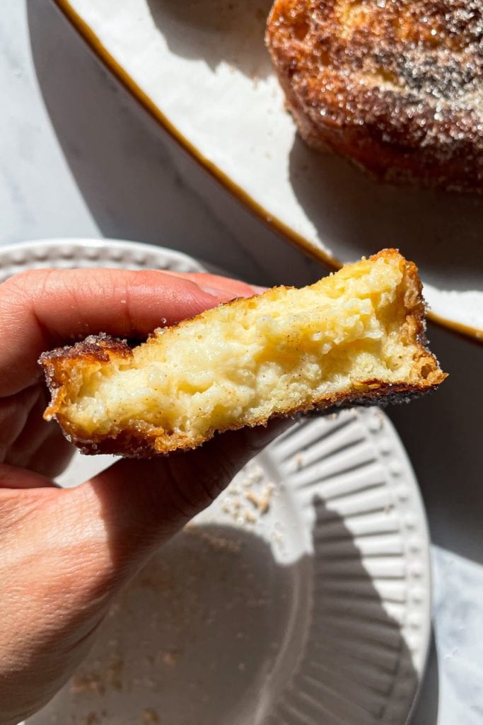 Receta para preparar las mejores Torrijas Tradicionales de leche, caseras, fáciles y quedan tan cremosas. Además, sirven como receta de aprovechamiento para no tirar pan duro. Un postre sencillo y delicioso de Semana Santa. En esta foto se ve el interior cremoso de la torrija. | Receta de Paula's Apron