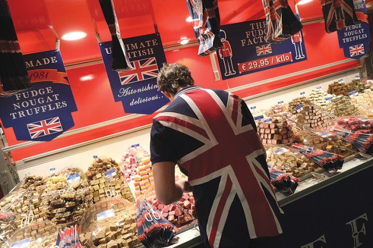 BERLIN, GERMANY - JANUARY 21: A sales assistant wearing a British flag arranges fudge at a British fudge manufacturer's stand at the International Green Week agricultural trade fair on January 21, 2019 in Berlin, Germany. The future of trade between the UK and the European Union is uncertain following the recent overwhelming rejection of British Prime Minister Theresa May's Brexit deal in the House of Commons last week. The International Green Week (Internationale Grüne Woche), among the biggest trade fairs of its kind, focuses on agriculture, horticulture and foods. (Photo by Sean Gallup/Getty Images)