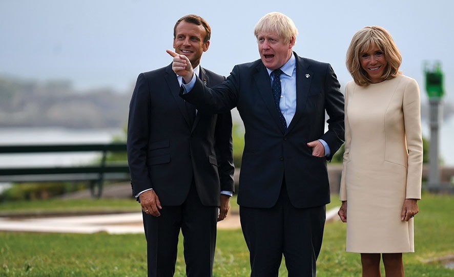 BIARRITZ, FRANCE - AUGUST 24: French President Emmanuel Macron (L), his wife Brigitte Macron (R) and British Prime Minister Boris Johnson pose for a photograph as they arrive for the G7 summit on August 24, 2019 in Biarritz, France. The French southwestern seaside resort of Biarritz is hosting the 45th G7 summit from August 24 to 26. High on the agenda will be the climate emergency, the US-China trade war, Britain's departure from the EU, and emergency talks on the Amazon wildfire crisis. (Photo by Neil Hall - Pool/Getty Images)