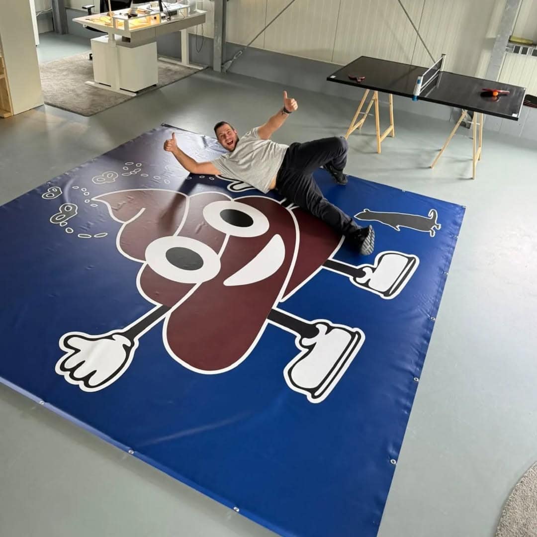 Das Bild zeigt ein großflächiges Werbebanner befestigt an einem Bauzaun