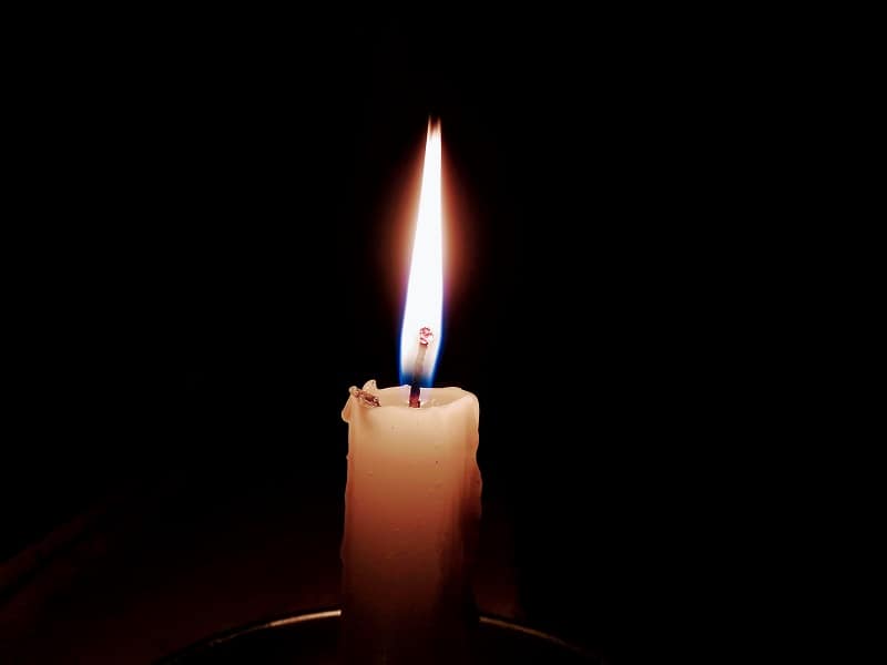 lit candle flame in darkness