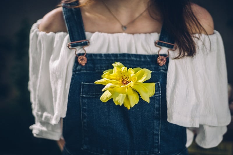 woman with yellow flower in pocket