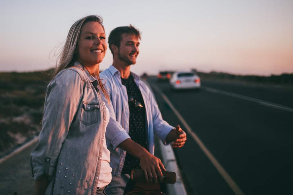 romantic couple smiling by a road