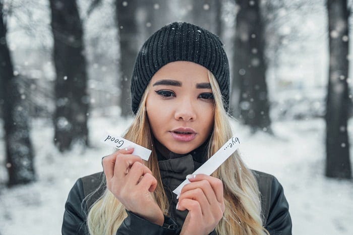 woman holding ripped paper that reads goodbye