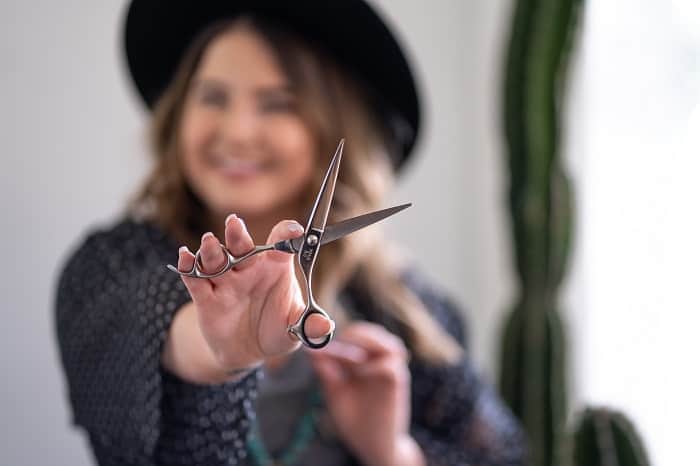 woman smiling holding scissors