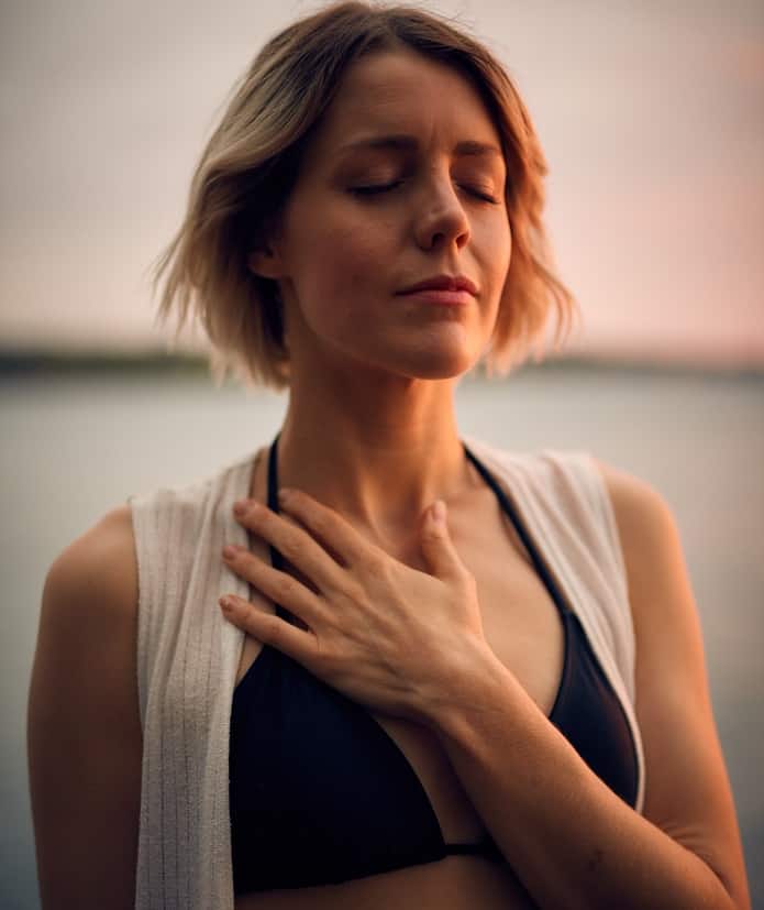 woman breathing and holding chest