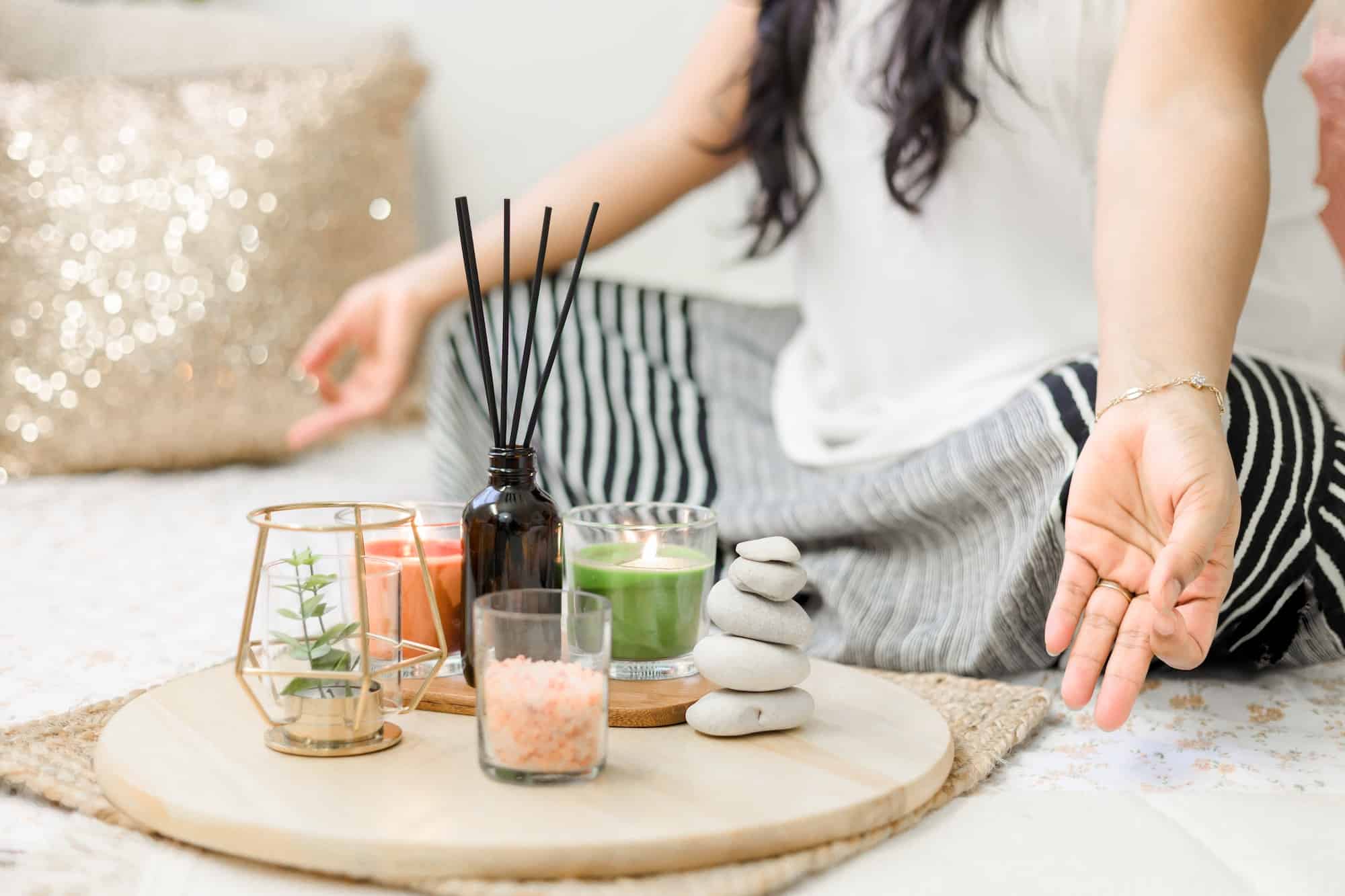 manifestation mantra law of attraction woman meditating with candles and incense