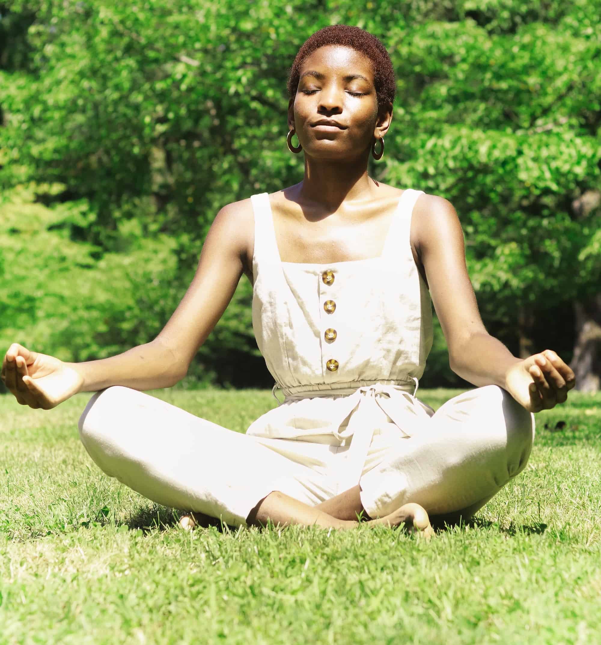 woman meditating on grass