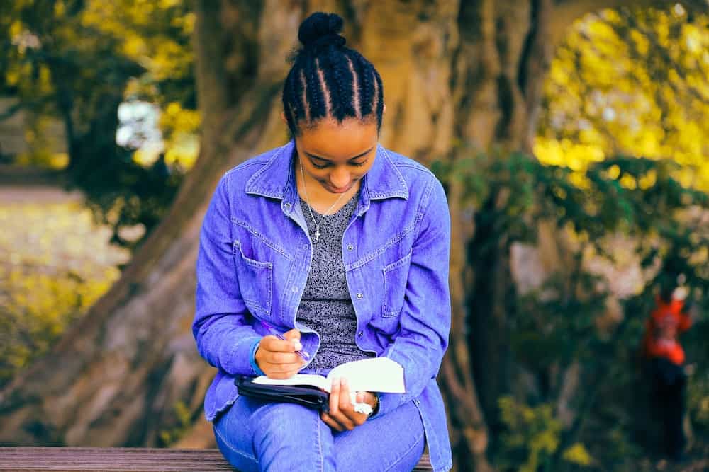 woman sitting writing in nature