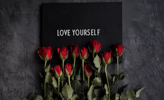 love yourself affirmation on sign with roses