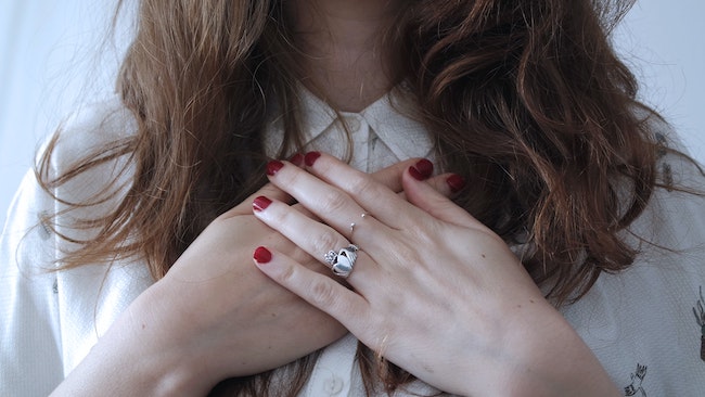 woman holding heart chakra area