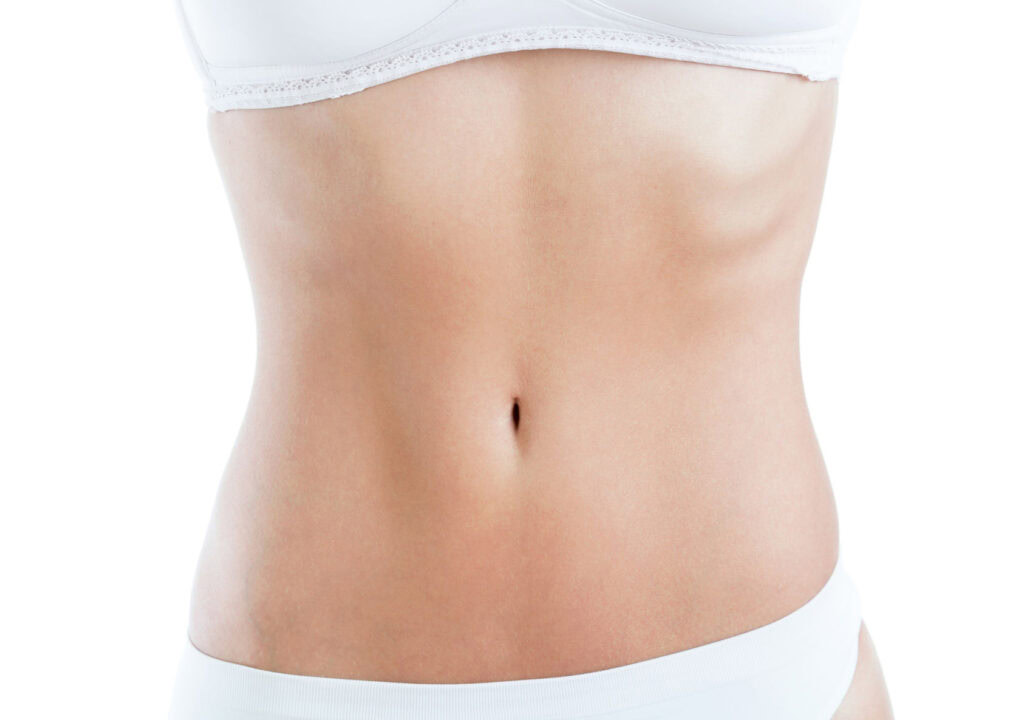 Close-up of slim woman body with flat abdomen