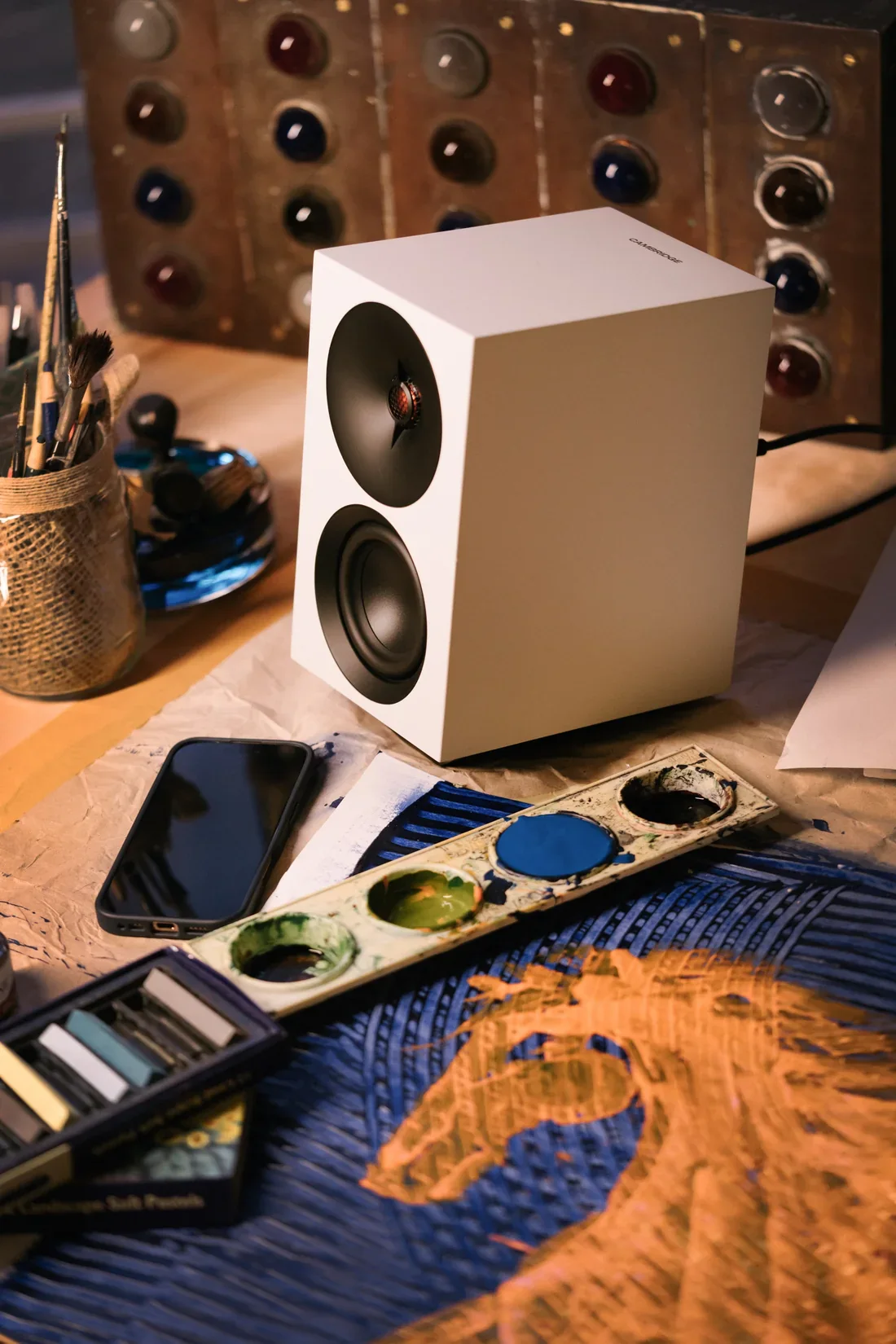 Enceinte Cambridge Audio L/R S blanche posee sur un bureau d atelier