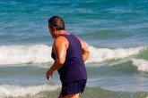 Man running on beach at best cheap fat camp