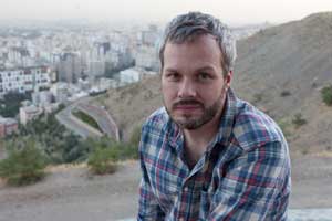 Portrait of photographer Stephan Lucka in front of Tehran´s skyline