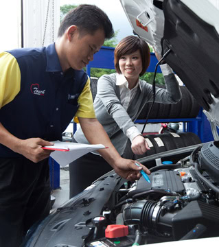Mechanic explaining vehicle service to woman