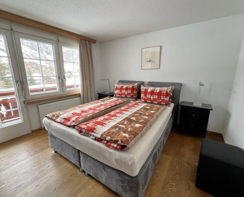 Schlafzimmer mit Boxsprsingbett und Holzboden