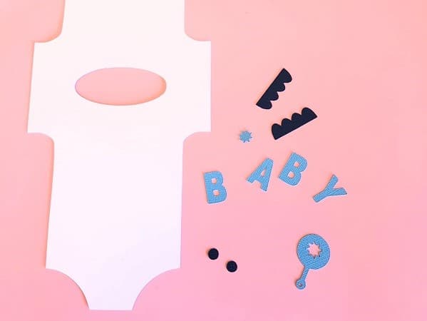 Pieces of the baby romper card ready to be assembled