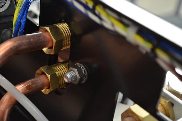 Copper tubing and high quality brass attachments in the back of a CIME espresso machine at the factory