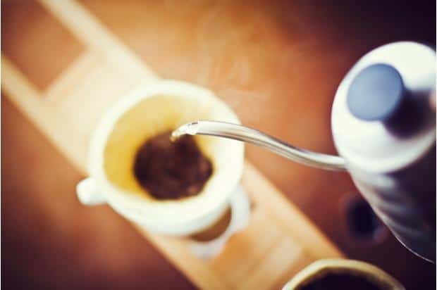 A Hario gooseneck kettle pours into a pourover cone