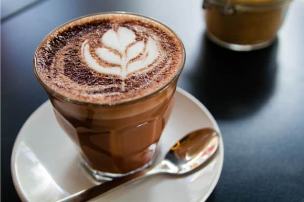 Glass of hot chocolate with espresso topped with a latte art tulip