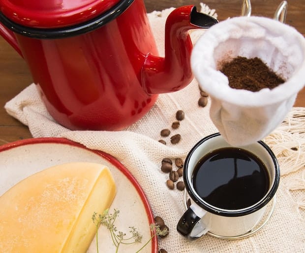 Coffee grounds suspended above a cup in a cloth filter