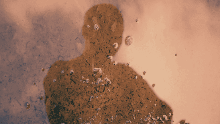 Spiegelung eines Mannes in einer Wasserpfütze als Symbol dafür, wie wichtig es ist, das eigene Rollenbild zu klären