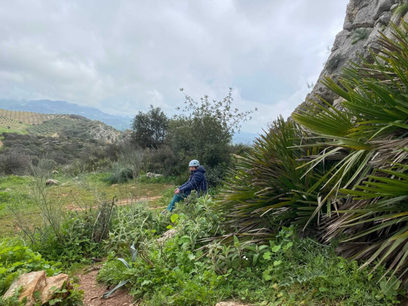 Mann sitzt in der Natur.