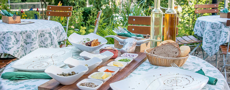Erfreuen Sie sich an herzhaften Speisen und kühlen Getränken in unserem idyllischen Biergarten. 