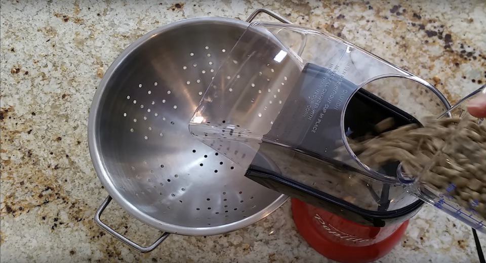 Pouring raw coffee beans into a popcorn popper