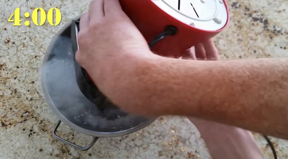 Smoke billows as the roasted beans are poured into the colander to cool