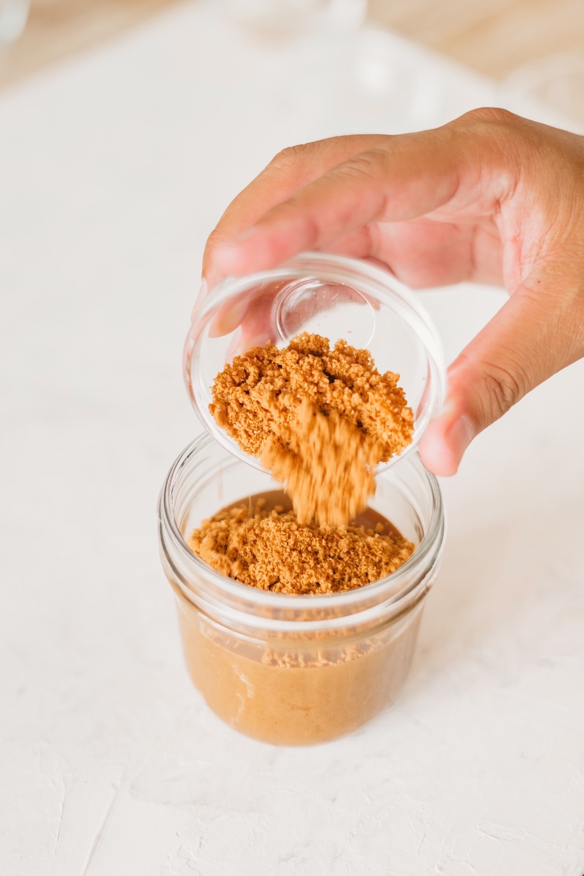 pouring crush biscoff into the finished spread