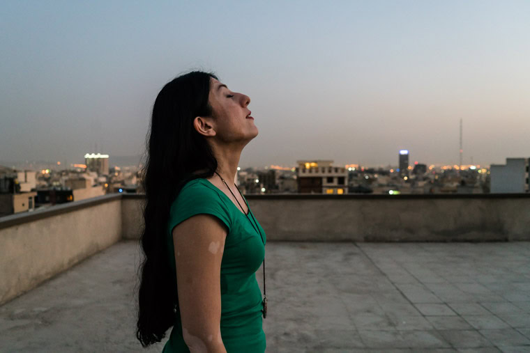 Iranian female singer Sayeh on the rooftop of her home in Tehran enjoying the sunset.